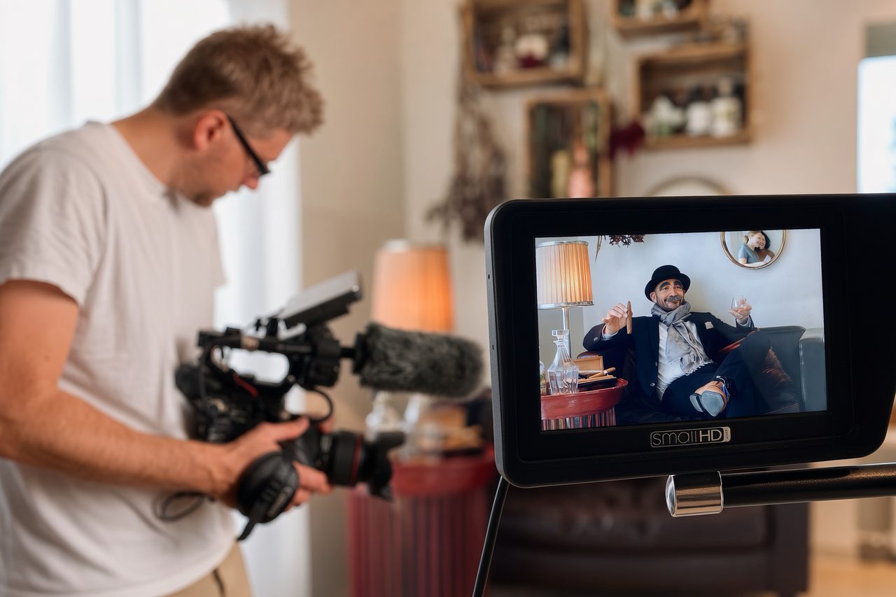 Maximilian Auer filmt ein Interview, im Vordergrund der Kontrollmonitor